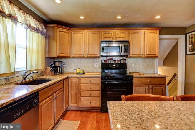 Before: the previous kitchen with oak cabinets, a black range and a granite peninsula.