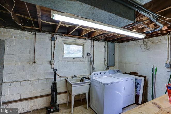 Before: the previous laundry area with bare block walls, exposed joists and a fluorescent light.