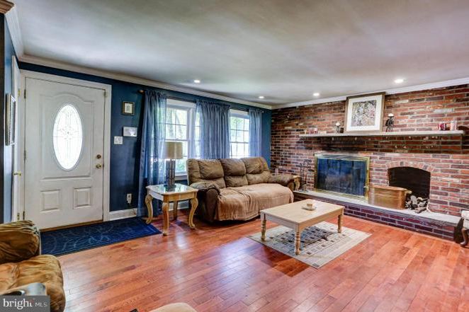 Before: the previous living room with dark blue walls, exposed red brick fireplace and older flooring.