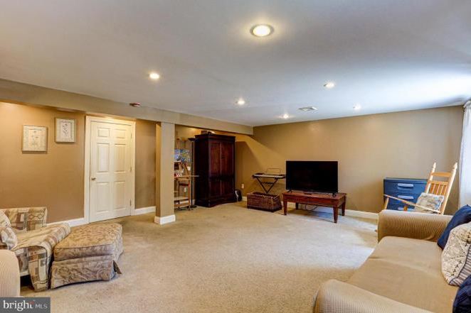Before: the previous lower-level room with carpet, beige walls and older furniture.