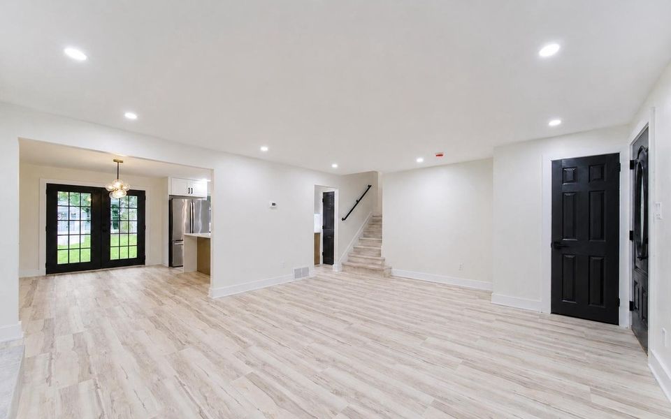 Open flow from the living room into the dining area and kitchen, with recessed lighting throughout.